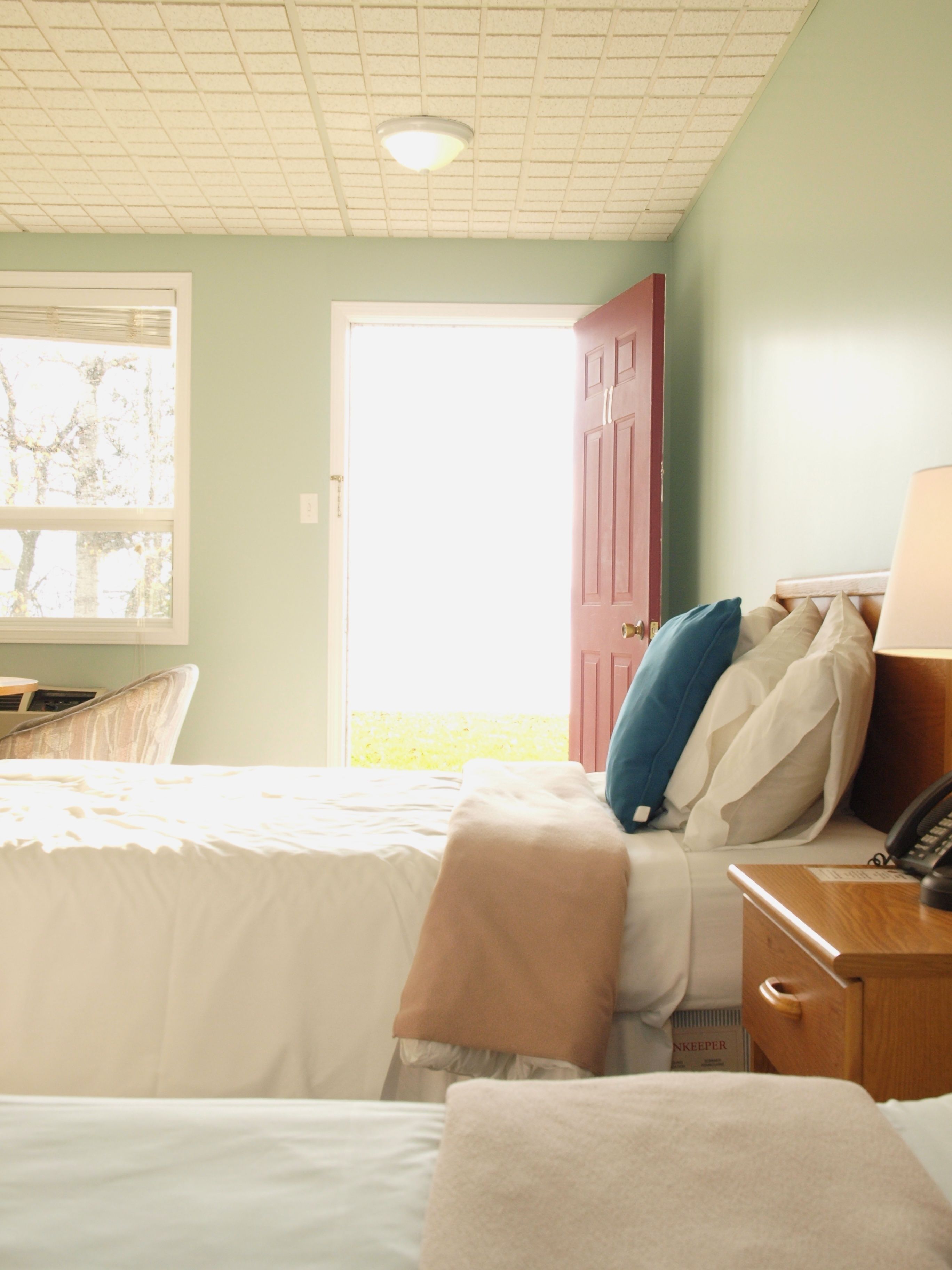 Ein Schlafzimmer mit einem Bett, einem Nachttisch und einem Fenster mit Jalousien.