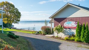 Ein Gebäude mit einem Schild, das "Sand's Spa Retreat, Relax, Restore" zeigt, mit Blick auf einen See und Berge im Hintergrund.