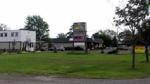 A motel with a row of single-story buildings, a parking lot, and a grassy area. - Wainfleet Motel & Restaurant (Wainfleet)