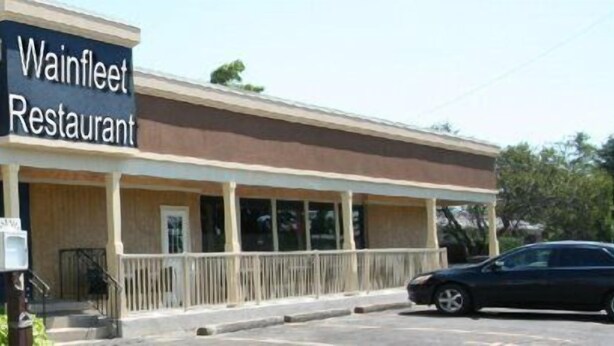 A Wainfleet Restaurant with a covered outdoor seating area and a parking lot. - Wainfleet Motel & Restaurant (Wainfleet)