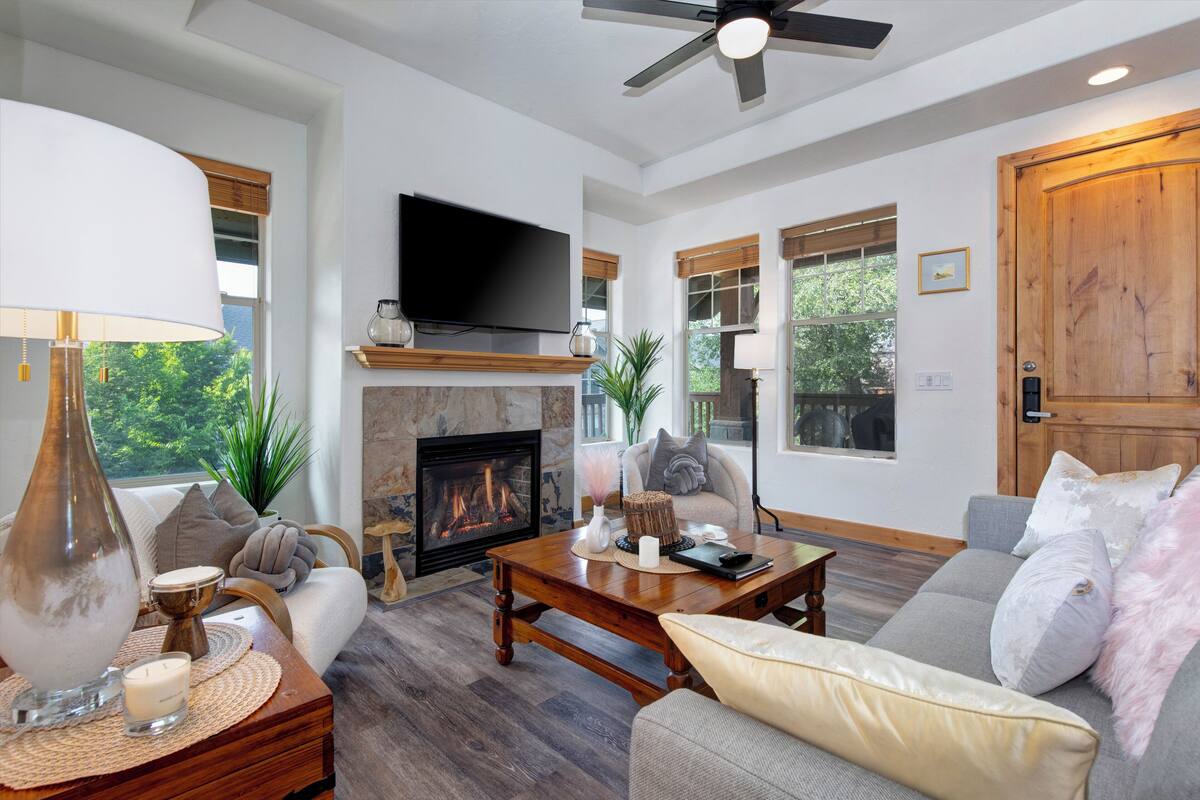 A spacious living room with a fireplace, a television, and comfortable seating.
