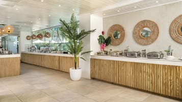 A modern kitchen with wooden cabinets, a central island, and a potted plant.