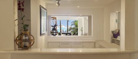 Una cocina moderna con vista a una piscina y palmeras.