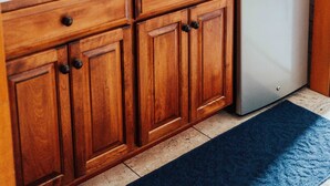 A kitchen with wooden cabinets, a stainless steel dishwasher, a microwave, and a granite countertop. - Town Hall Inn (Lead)