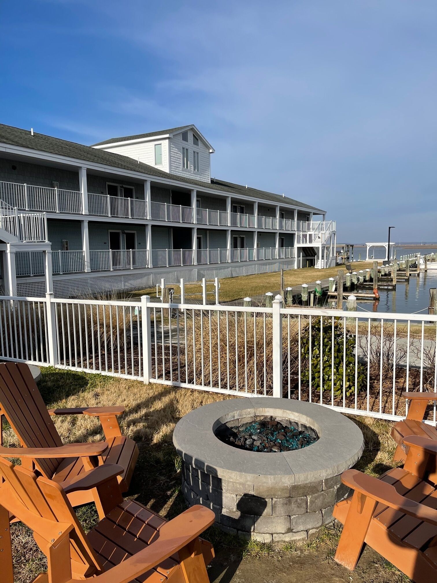 A multi-story building with balconies, a fire pit, and outdoor seating.