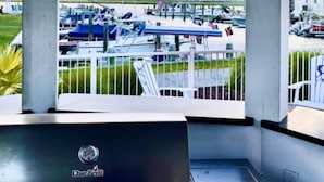 A covered outdoor area with a view of boats and a marina. - Anchor Inn (Chincoteague)