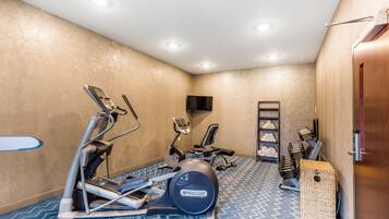 Una palestra con attrezzature per esercizi, tra cui tapis roulant ed ellittica.