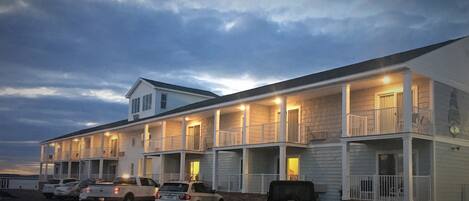 A motel with multiple rooms, a parking lot, and a brick facade.