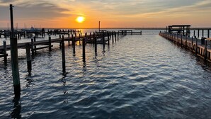 A pier extending into calm waters with a sunset in the background. - Anchor Inn (Chincoteague)