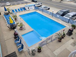 Una piscina al aire libre de temporada, sillones reclinables de piscina