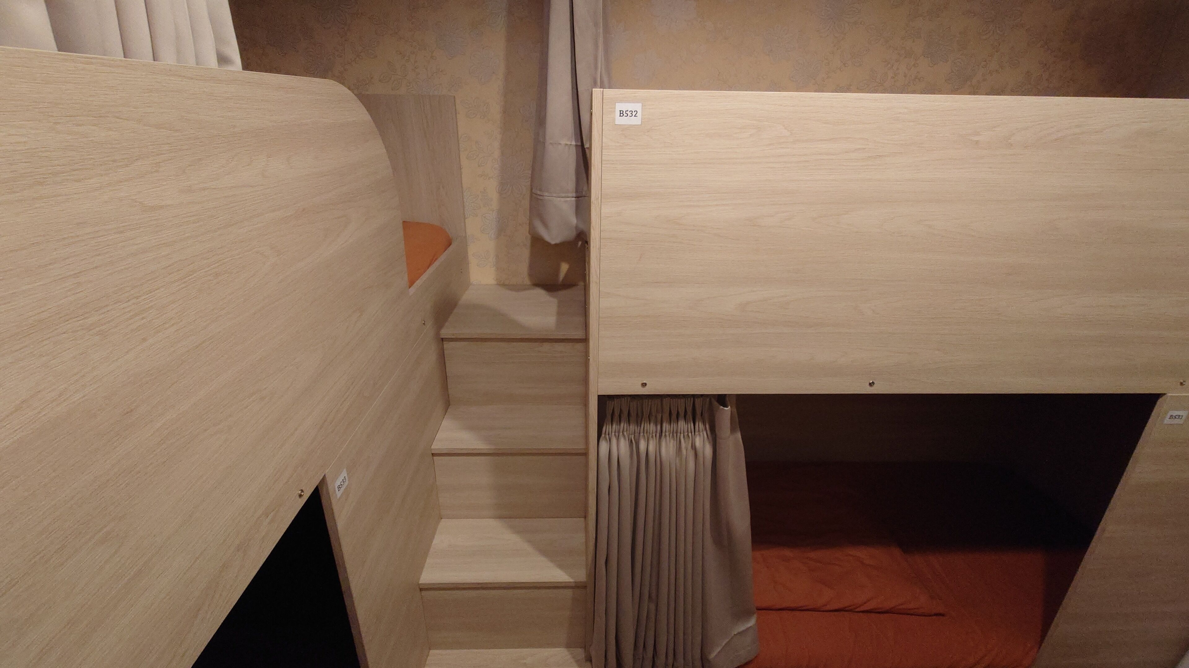 Un aménagement compact, avec une seule pièce comprenant un lit superposé et un petit escalier menant à un niveau inférieur.