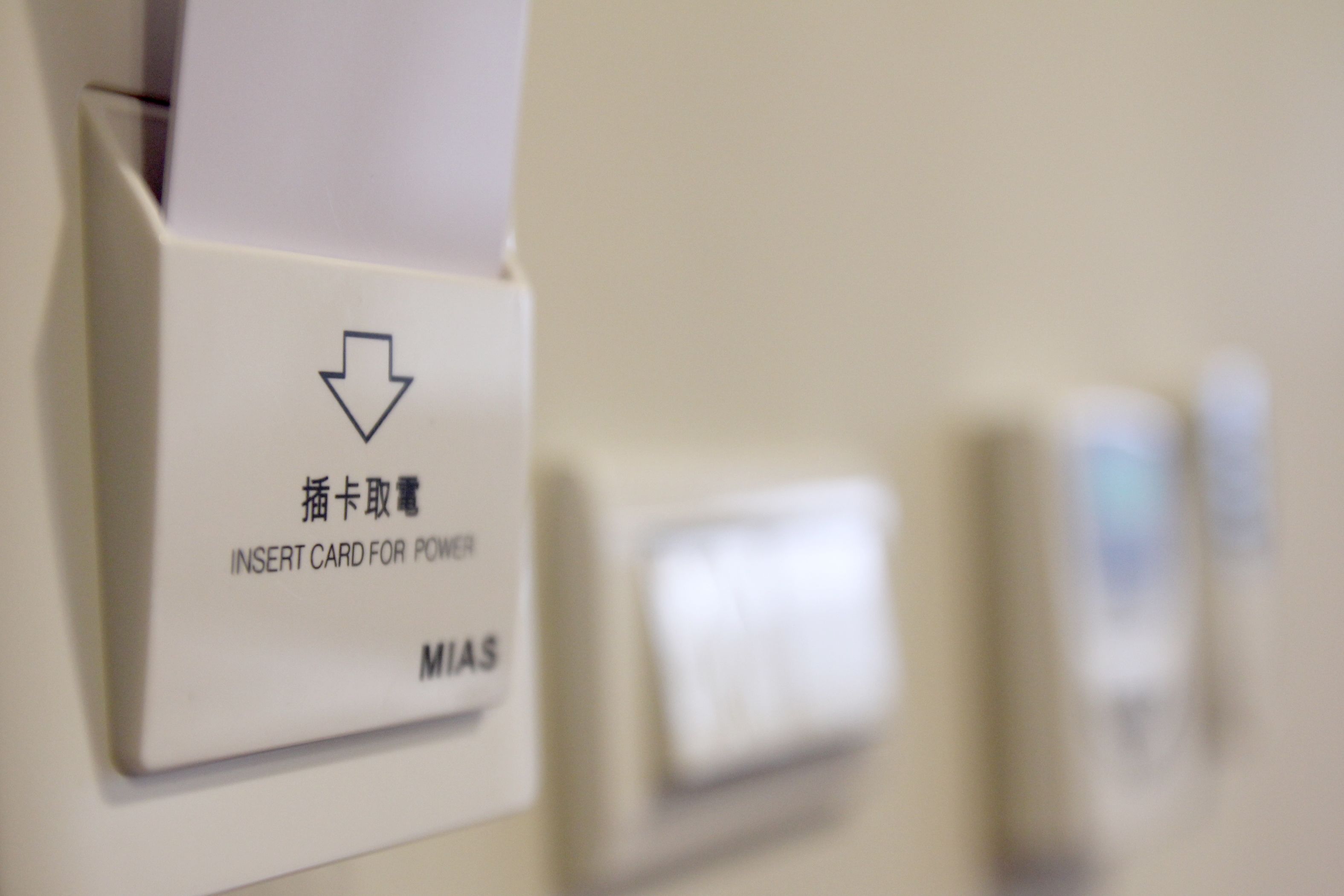 A card reader with instructions in multiple languages for inserting a card to power a device.