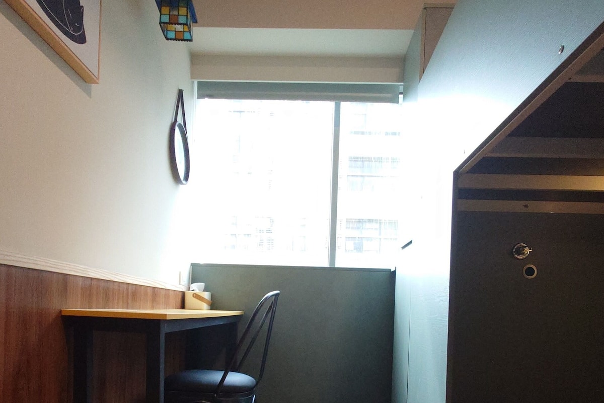 A room with a bunk bed, a desk, and a chair.