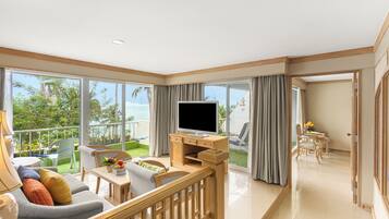 A spacious living area with a balcony, a flat-screen TV, and a dining set.