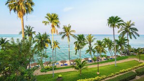A beach resort with palm trees, a pathway, and beach chairs. - Royal Cliff Beach Terrace Hotel Pattaya (Pattaya)