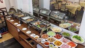 A buffet with various food items and dishes.