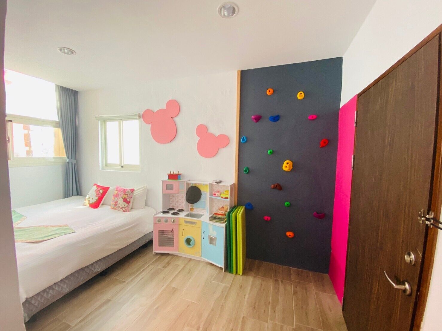 A child's bedroom with a bed, play area, and a wardrobe.