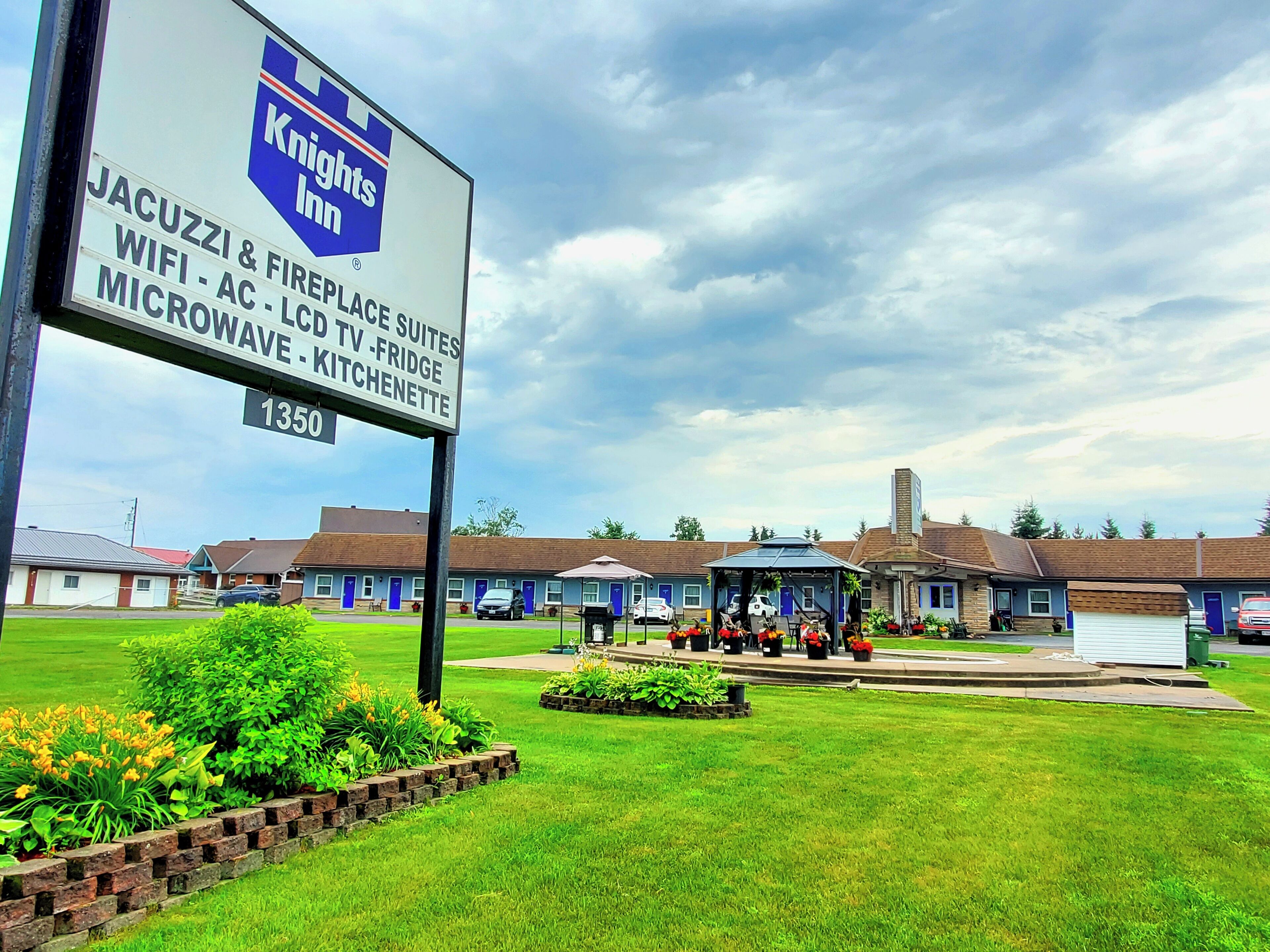 Señal de Knights Inn con servicios como jacuzzi, WiFi, suites con chimenea y cocinetas.