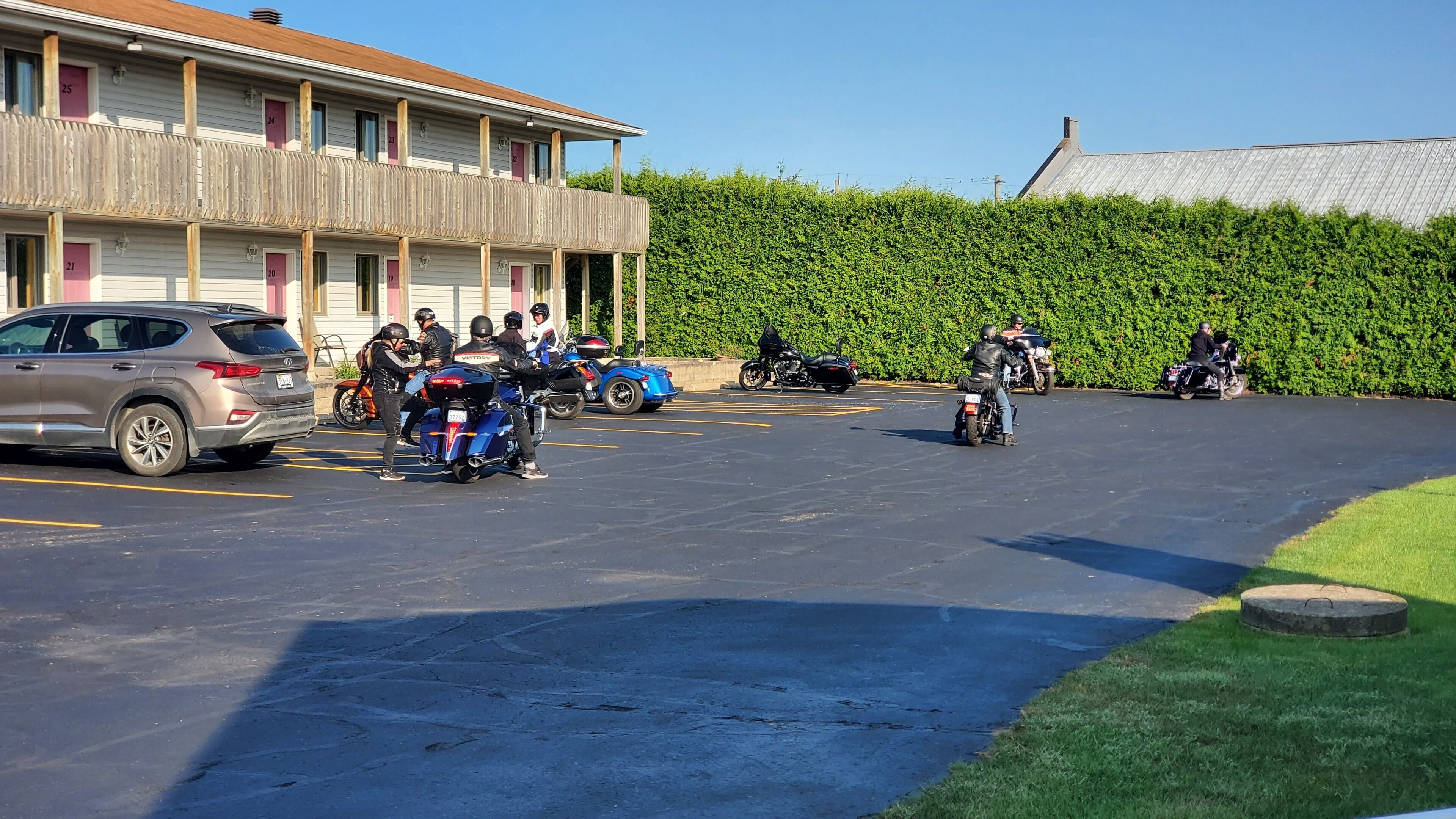 A parking area with several motorcycles and a car.