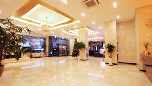 A spacious lobby with a polished marble floor, large columns, and potted plants. - Sunshine Hotel (Daejeon)