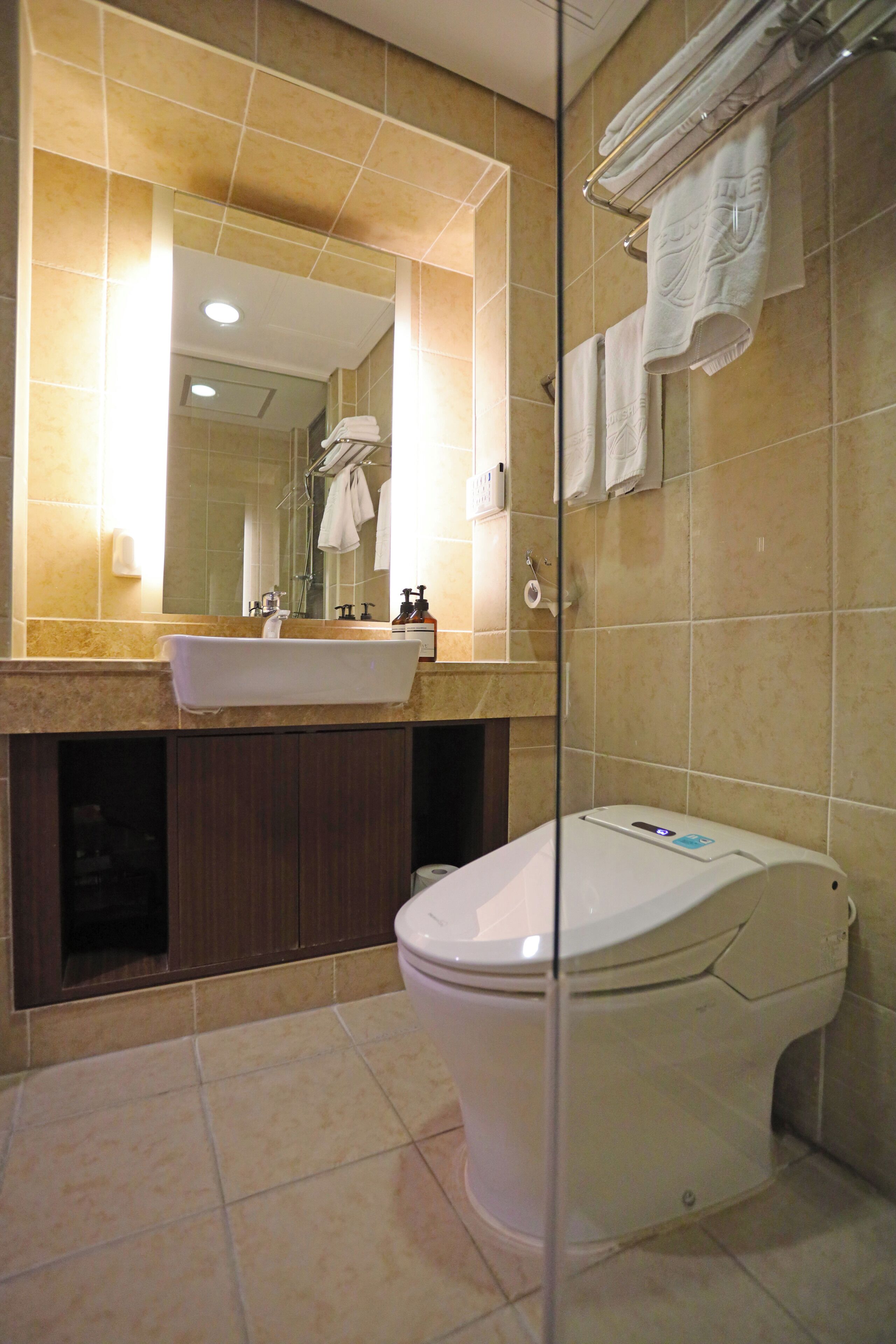 Un baño con lavamanos, espejo e inodoro.