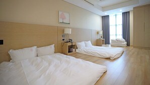 A hotel room with two beds, a bedside table with a lamp, a phone, and a window with curtains. - Sunshine Hotel (Daejeon)