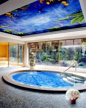 An indoor swimming pool with a tropical mural on the ceiling, surrounded by glass walls and tropical plants. - HARRIWAY GARDEN HOTEL CHANG AN (Dongguan)