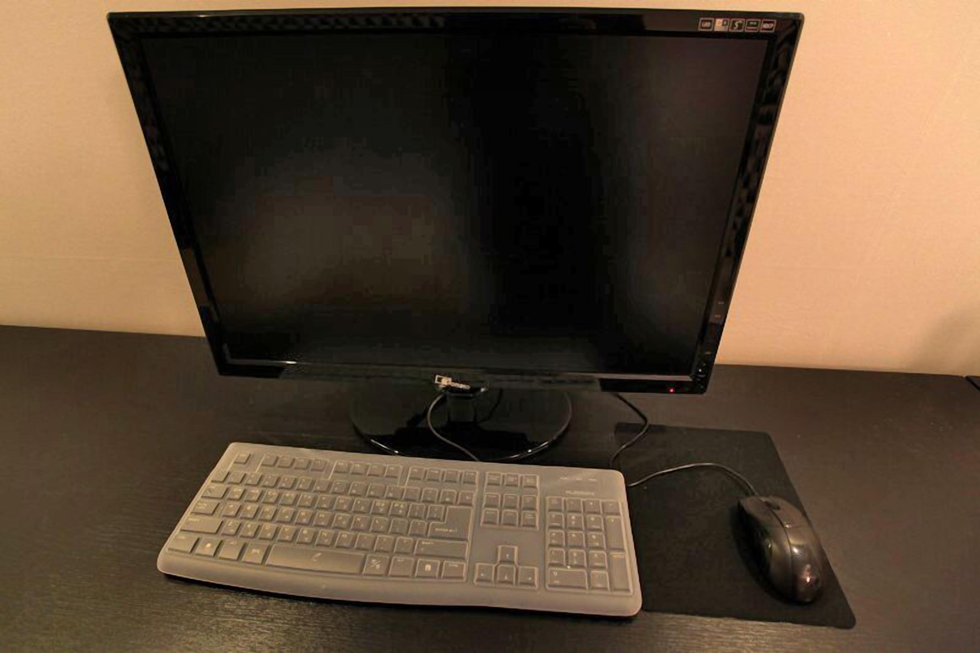Een computeropstelling met een beeldscherm, toetsenbord en muis op een bureau.