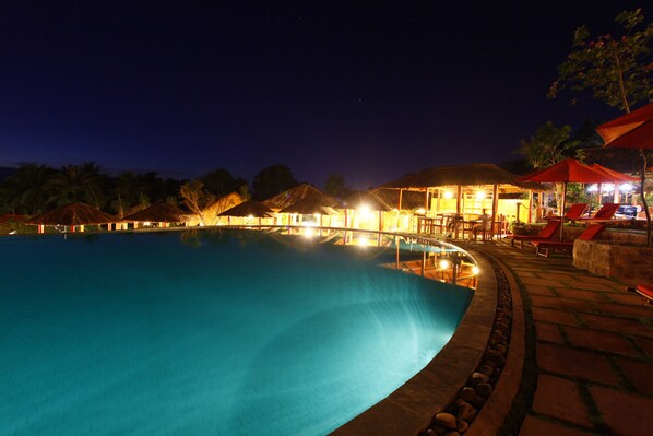 Alberca al aire libre, sombrillas en la alberca y camastros 