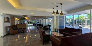 A spacious lobby with seating areas, a reception desk, and large windows offering a view of the outdoors. - Sunday Beachfront View Jomtien Pattaya (Pattaya)