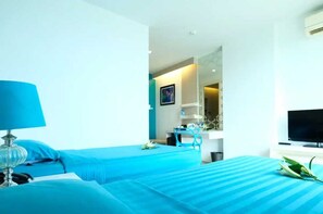 A hotel room with two beds, a TV, a desk, and a chair. - Sunday Beachfront View Jomtien Pattaya (Pattaya)