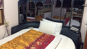 A bed with a patterned bedspread, a white pillow, and a headboard with mirrors. - Busan Jang Motel (Busan)
