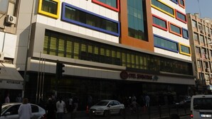 Un hotel de varios pisos con una fachada moderna que presenta marcos rectangulares en varios colores.