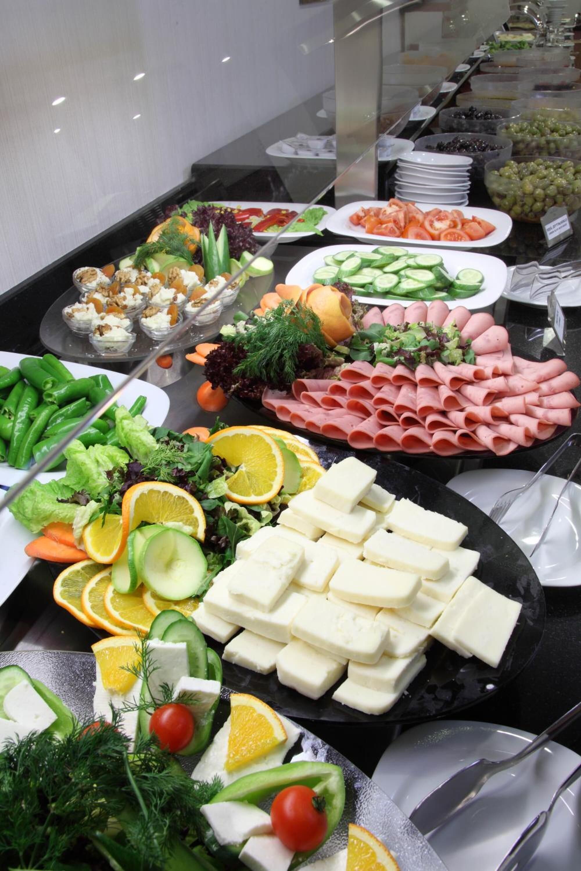Een buffet met diverse soorten eten, zoals groenten, fruit en kazen.