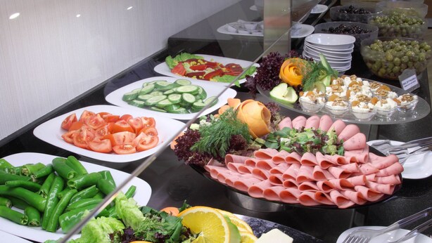 Un bufé con diversos alimentos, como verduras, frutas y quesos.