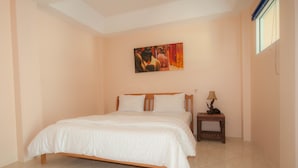 A bedroom with a bed, a nightstand, a lamp, and a painting on the wall. - Narnia Resort Pattaya 2 (Sattahip)