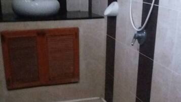 A bathroom with a toilet, a sink, and a shower.