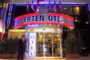 Entrada do hotel ERTEN OTEL, com balcão de recepção e placa indicando a área da recepção.