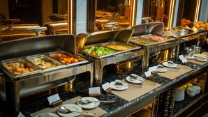 Ein Buffet mit verschiedenen Speisen, darunter Obst, Gemüse und Fleisch.