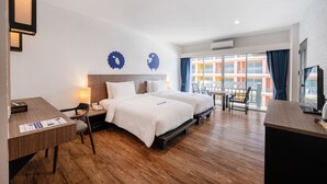 Une chambre d’hôtel avec deux lits, un bureau, une chaise et un téléviseur.