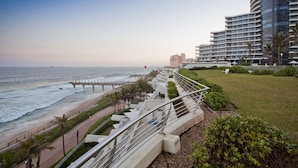 Ein Küstenhotel mit Blick auf den Ozean, eine Promenade und eine Brücke.