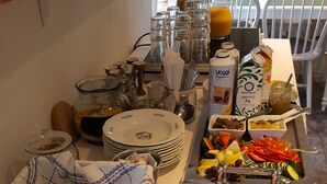 Una mesa de buffet con diversos alimentos, como carnes, quesos y pasteles.