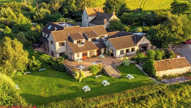 A large stone house with multiple rooms and a spacious outdoor area with picnic tables. - Cameley Lodge (Bristol)