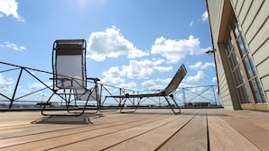 A wooden deck with two sun loungers and a railing. - B&B Back2Front (Ypres)