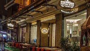 A hotel with a restaurant and cafe on the ground floor, featuring a classic architectural style with ornate details and warm lighting. - Empire Suite Hotel (Istanbul)