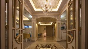 A luxurious hallway with ornate gold detailing, a grand chandelier, and a patterned floor. - Empire Suite Hotel (Istanbul)