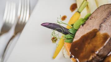 A plate of food with a fork and knife on the left.
