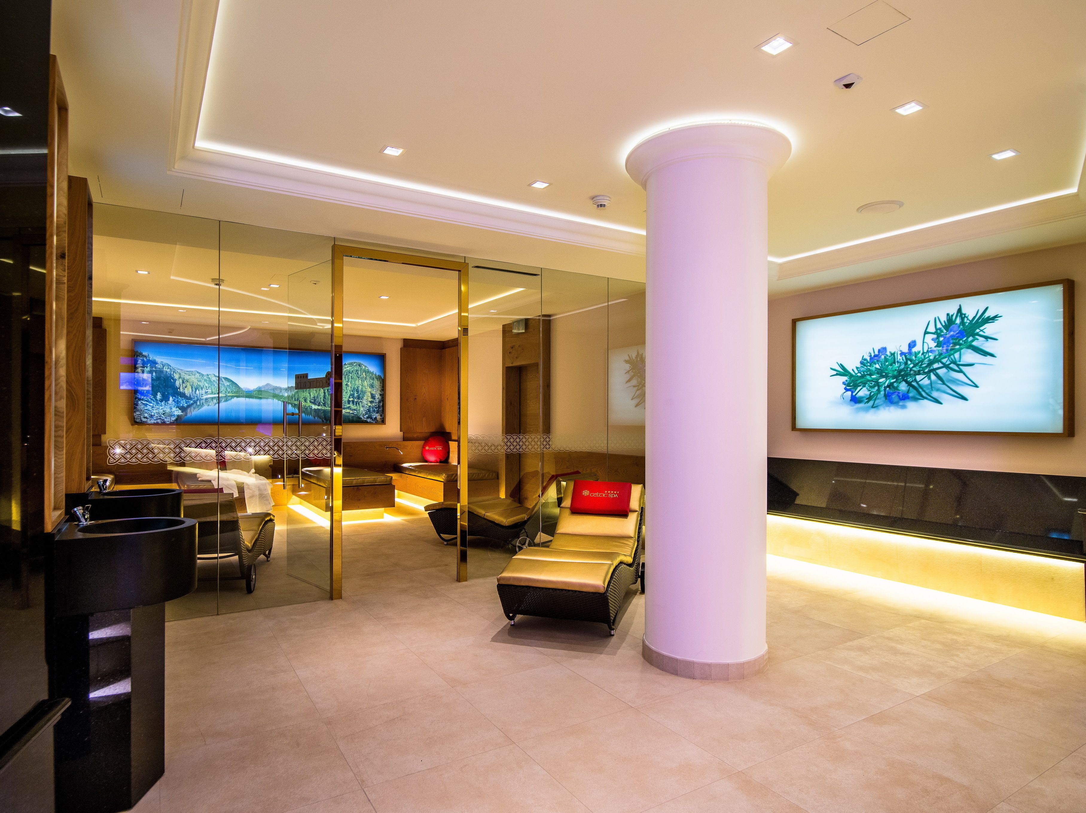 A modern lobby with a large TV, comfortable seating, and a reception desk.