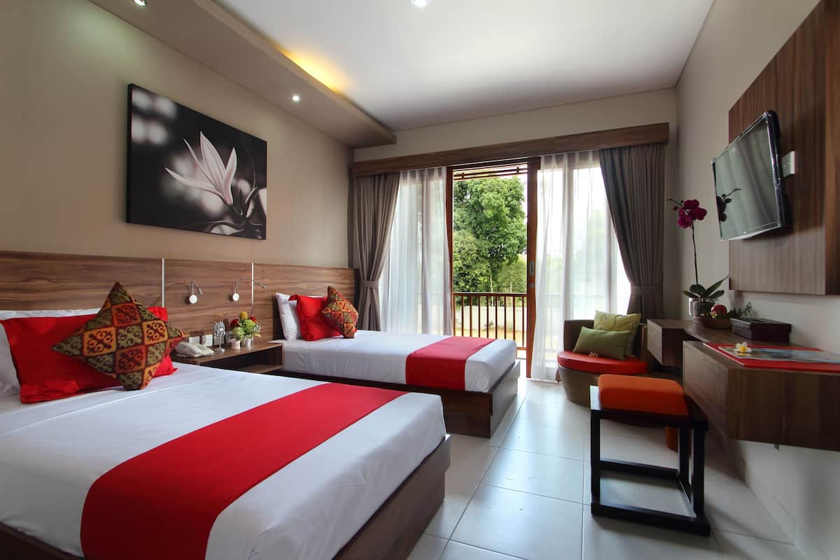 A hotel room with two beds, a desk, a chair, a TV, and a balcony with curtains.