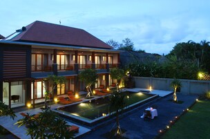 Una casa moderna de dos pisos con piscina, mobiliario exterior y un patio bien iluminado.